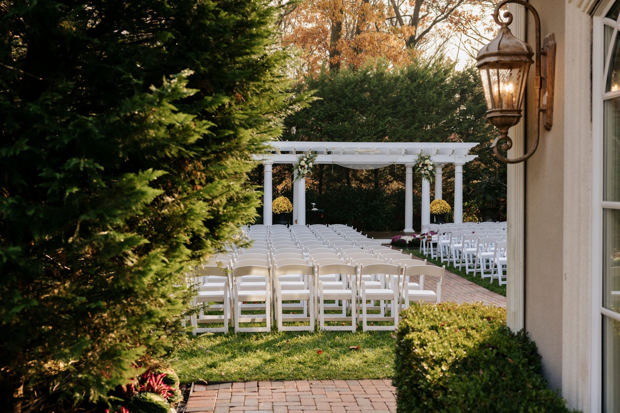 White garden pergola and ceremony chairs at The Bradford Estate in autumn