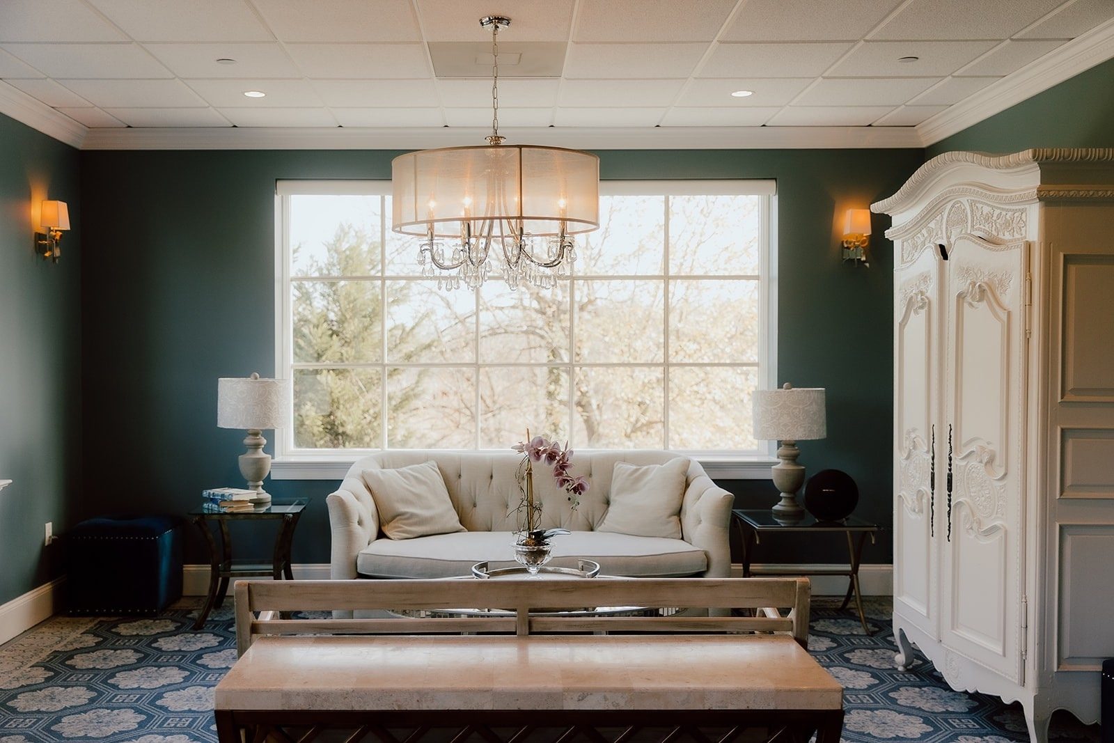 Bridal suite lounge with tufted sofa, chandelier and garden view